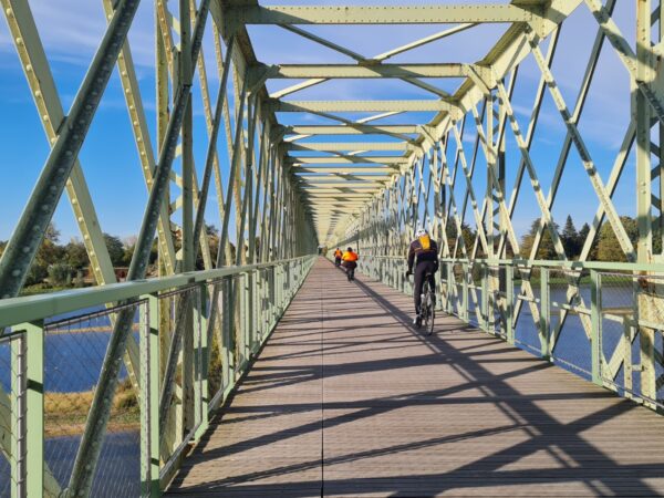 Ancien pont de chemin de fer réhabilité en pont de passage pour les vélos et piétons. Pont en fer vert avec des cycliste passant reliant Sully sur Loire à Saint père sur Loire