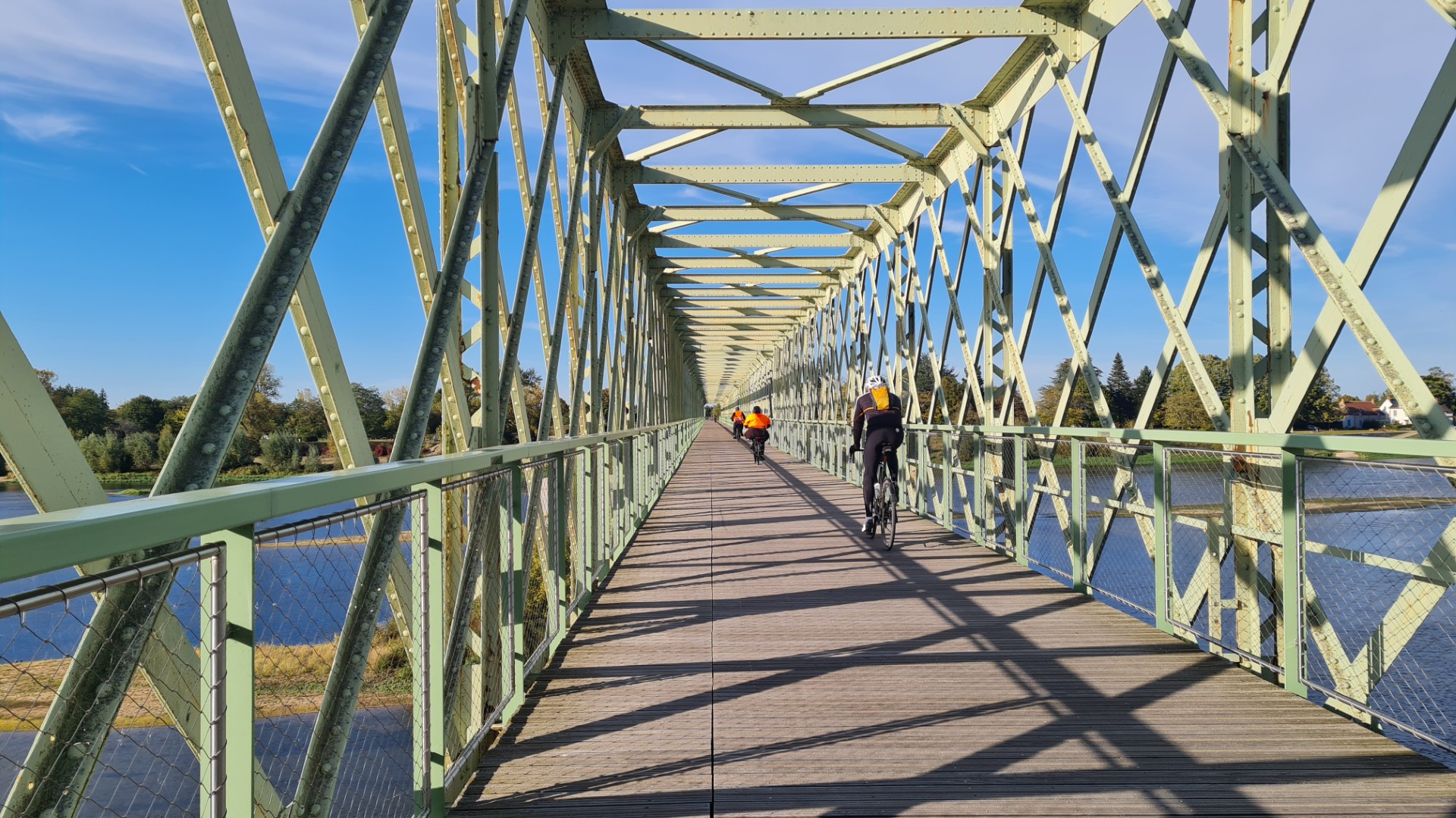 Ancien pont de chemin de fer réhabilité en pont de passage pour les vélos et piétons. Pont en fer vert avec des cycliste passant reliant Sully sur Loire à Saint père sur Loire