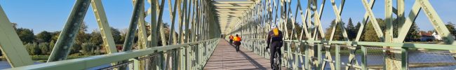Ancien pont de chemin de fer réhabilité en pont de passage pour les vélos et piétons. Pont en fer vert avec des cycliste passant reliant Sully sur Loire à Saint père sur Loire